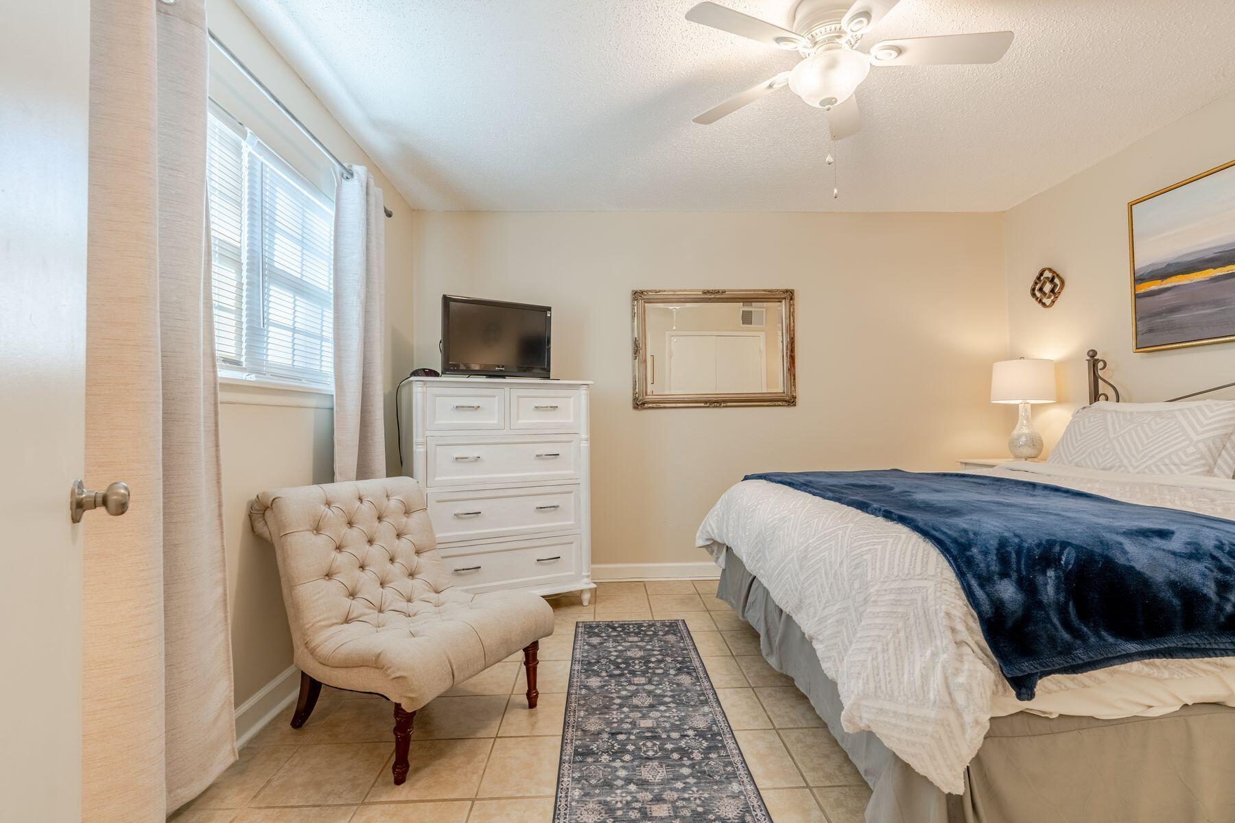 56 Sunset Bay, Unit 17B Miramar Beach, FL 32550 - Photo 14 of 30 a bedroom with a bed and a chair