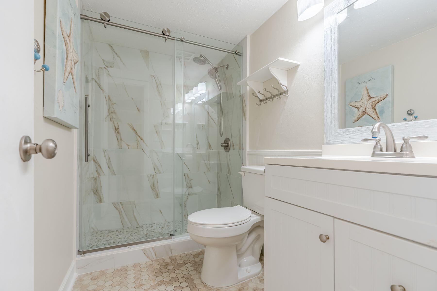 56 Sunset Bay, Unit 17B Miramar Beach, FL 32550 - Photo 17 of 30 a bathroom with a shower a toilet and a sink