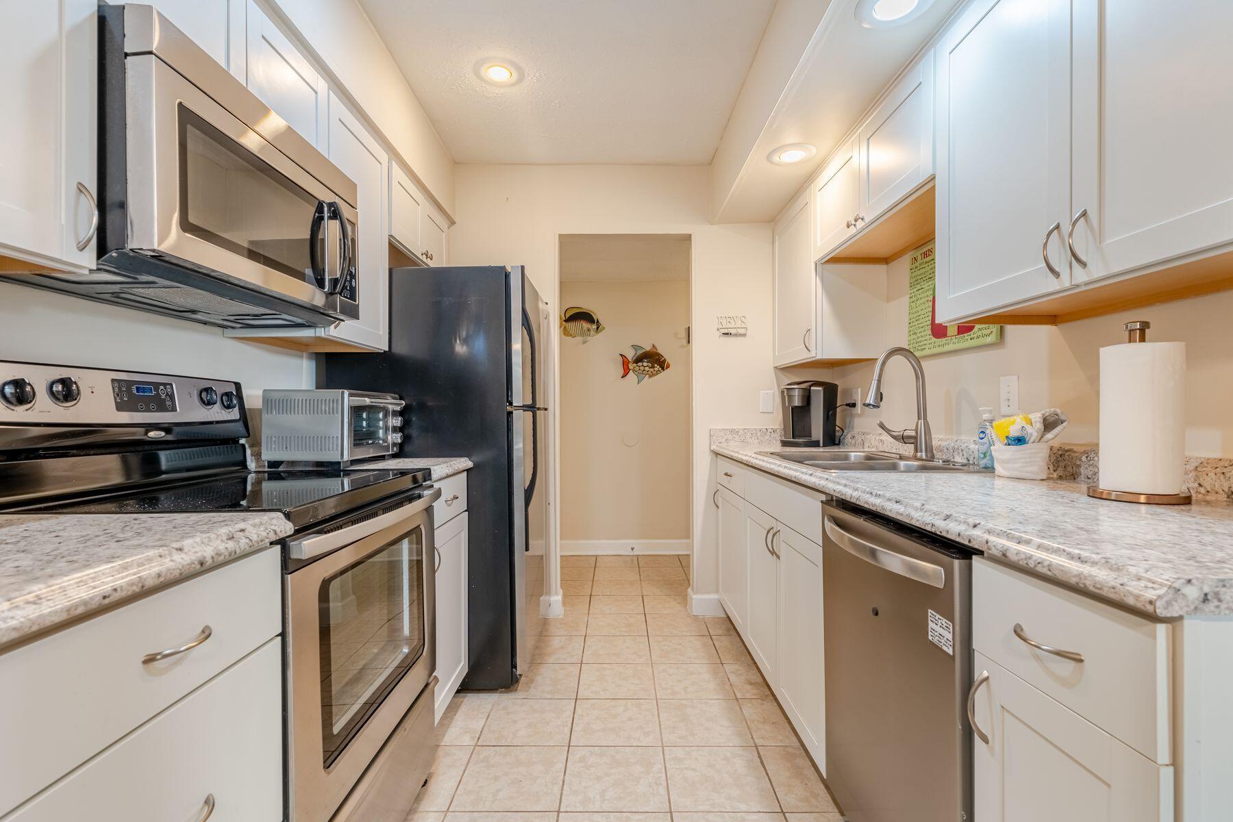 56 Sunset Bay, Unit 17B Miramar Beach, FL 32550 - Photo 2 of 30 a kitchen with stainless steel appliances granite countertop a refrigerator a stove and a sink
