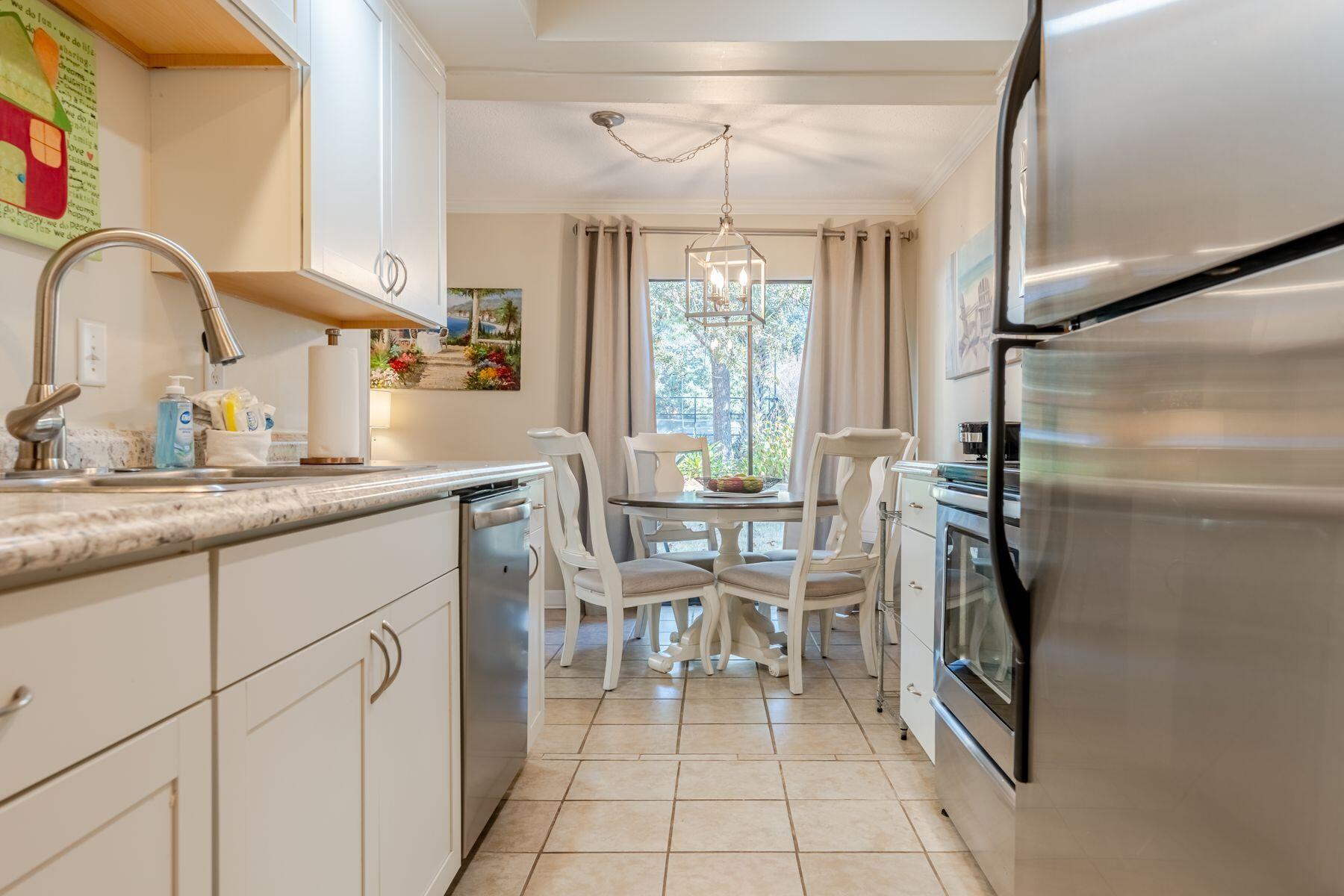 56 Sunset Bay, Unit 17B Miramar Beach, FL 32550 - Photo 3 of 30 a kitchen with stainless steel appliances granite countertop a sink and a refrigerator