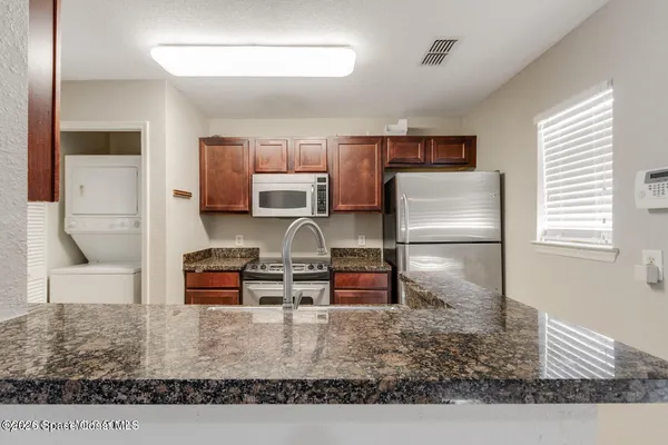 a kitchen with kitchen island granite countertop a refrigerator stove and sink