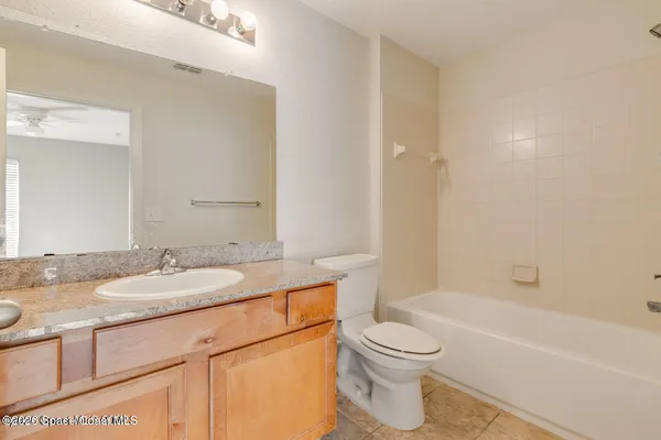 a bathroom with a granite countertop sink toilet a mirror and bathtub