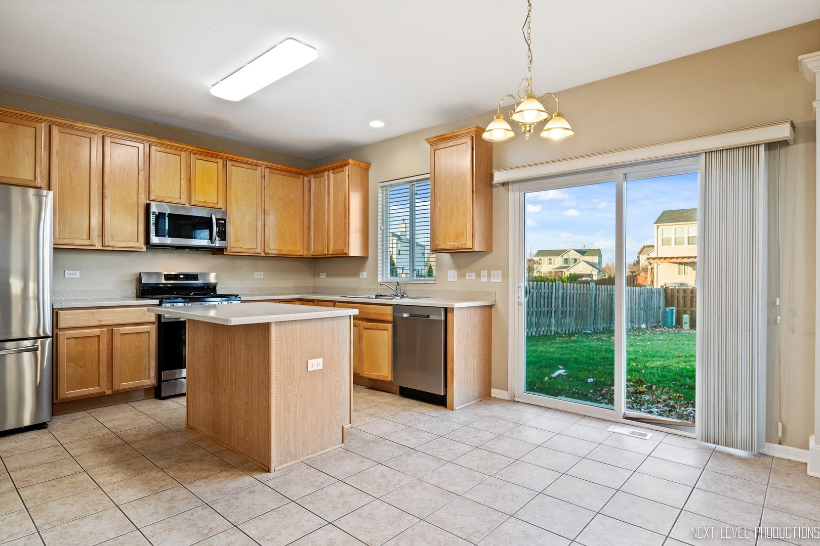 230 Tiger Street Bolingbrook, IL 60490 - Photo 11 of 27 a kitchen with stainless steel appliances granite countertop a stove top oven a sink dishwasher a refrigerator and a microwave