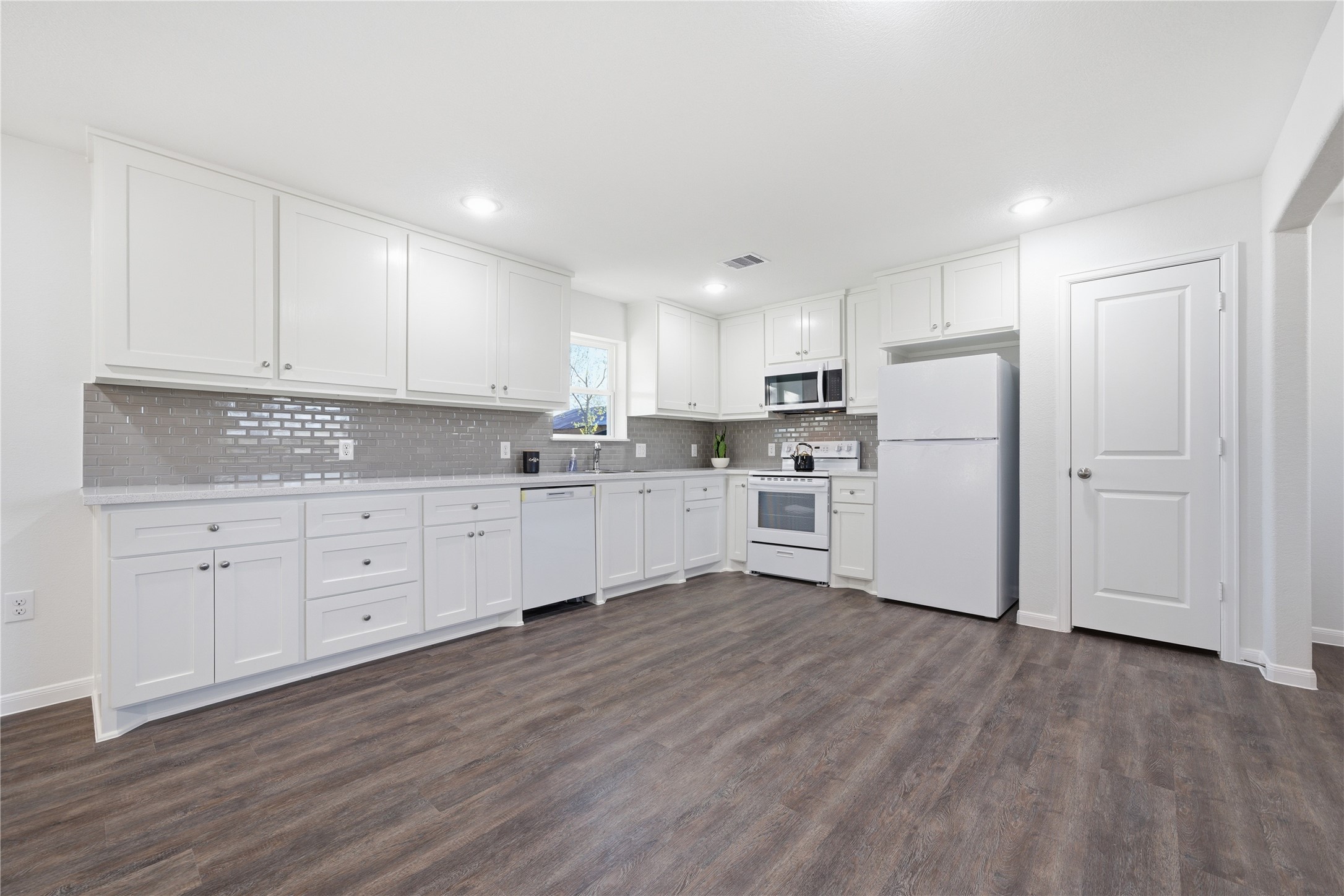6623 County Road 4 Damon, TX 77430 - Photo 11 of 48 a kitchen with white cabinets and white stainless steel appliances