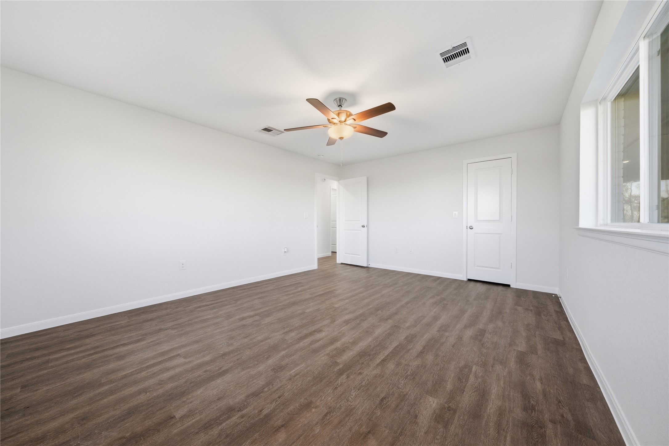 6623 County Road 4 Damon, TX 77430 - Photo 17 of 48 an empty room with wooden floor and ceiling fan