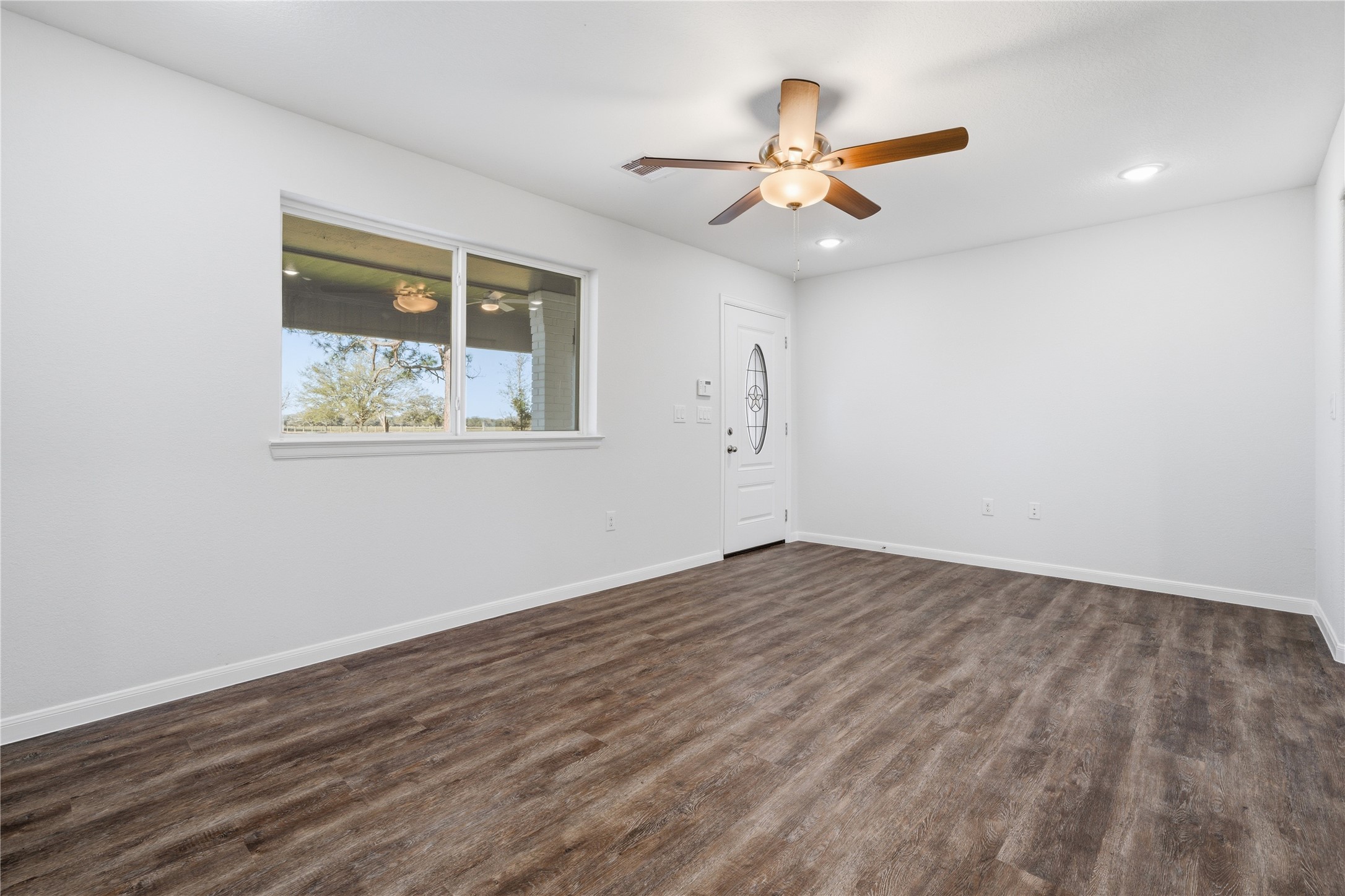 6623 County Road 4 Damon, TX 77430 - Photo 20 of 48 a view of an empty room with wooden floor and a ceiling fan