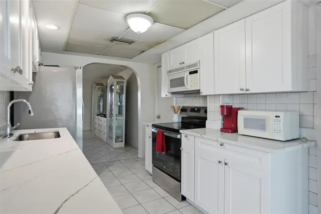 a kitchen with a sink dishwasher a refrigerator and cabinets