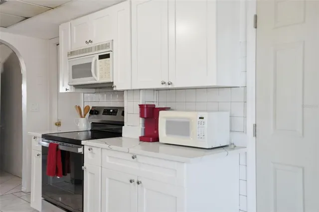 a kitchen with stainless steel appliances kitchen island granite countertop a sink and cabinets