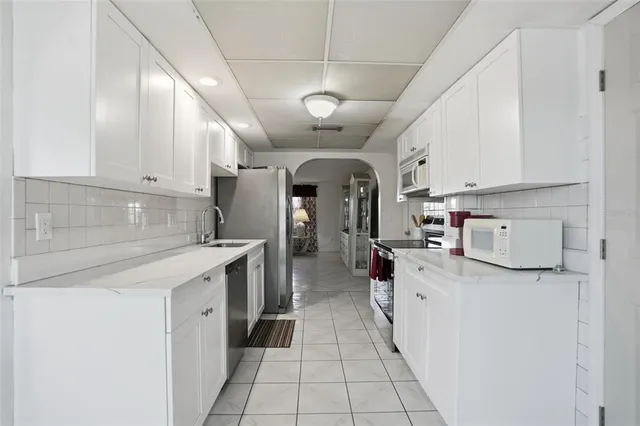 a kitchen that has a sink stainless steel appliances and cabinets