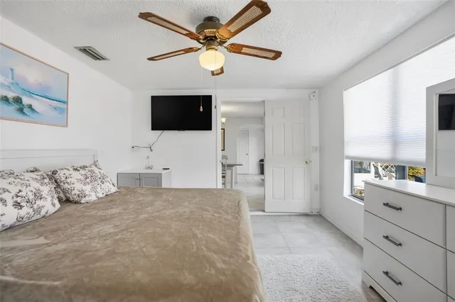 a bedroom with a bed a couch and a flat screen tv