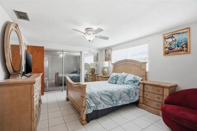 a bedroom with a large bed and a flat tv screen on dresser