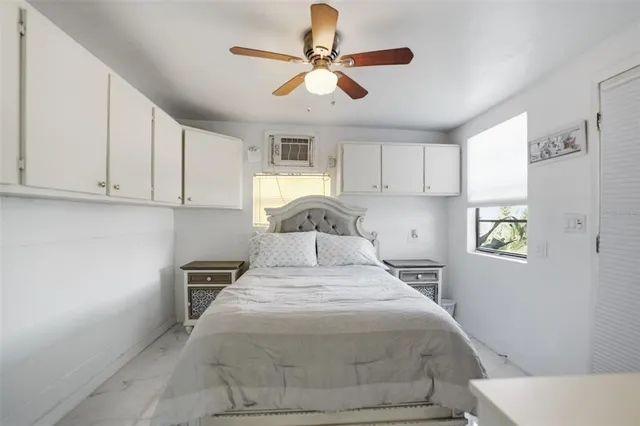 a bedroom with a bed a flat screen tv and cabinets