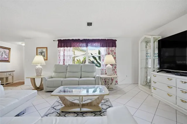 a living room with furniture a flat screen tv and a flat screen tv