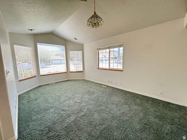 798 South 600 East Payson, UT 84651 - Photo 11 of 31 Spacious room featuring vaulted ceilings, a prominent bay window, green carpeting, white baseboards, and a central chandelier