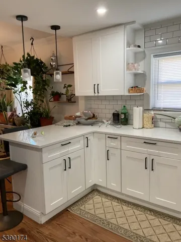 a kitchen with granite countertop white cabinets and white appliances