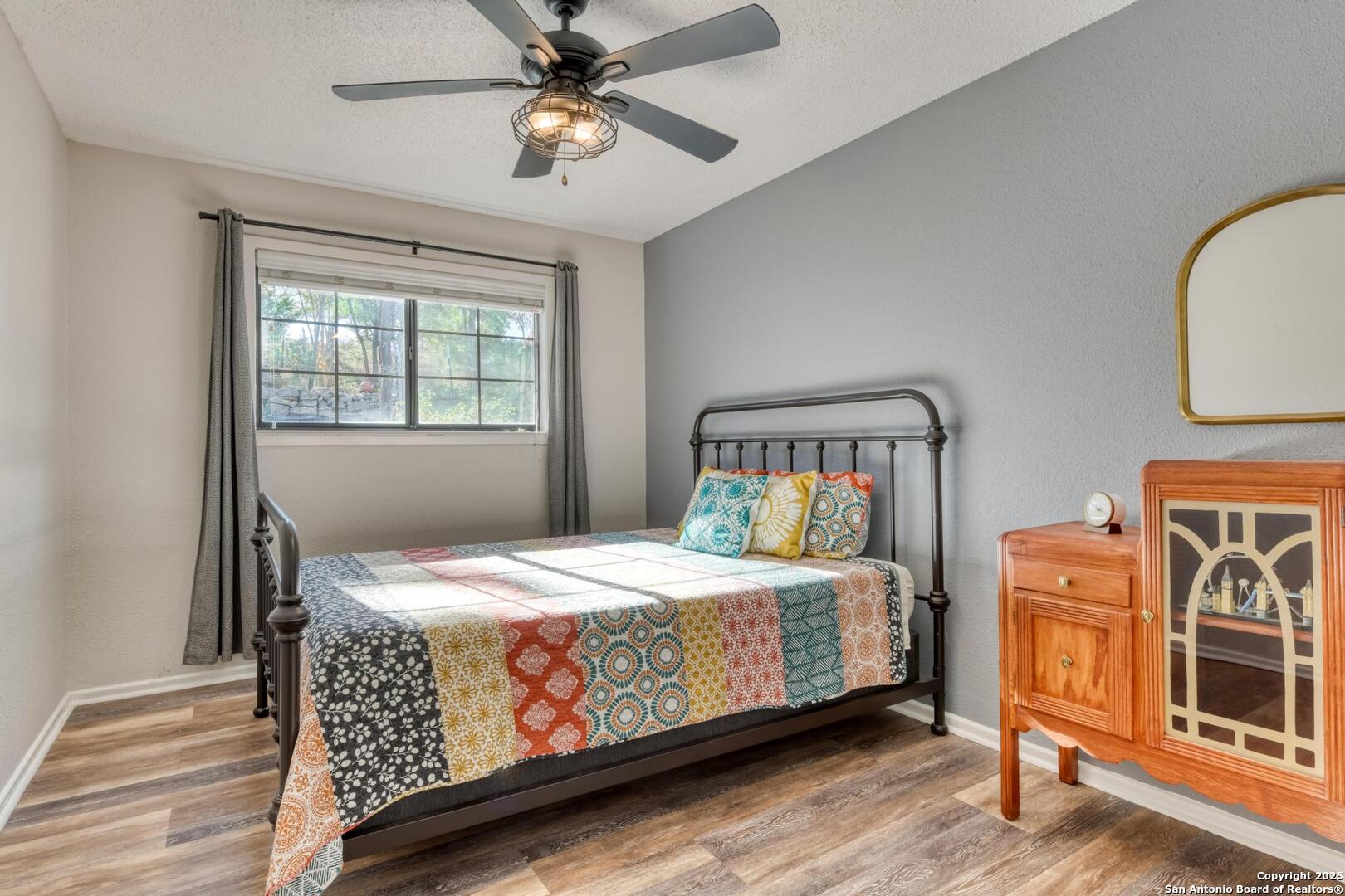 105 Shane Lane Boerne, TX 78006 - Photo 31 of 64 a bedroom with a bed and a chandelier