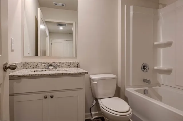 a bathroom with a sink toilet vanity and tub