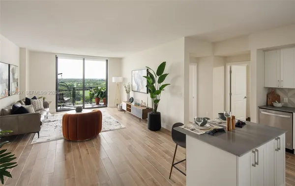 a living room with furniture a large window wooden floor and a rug