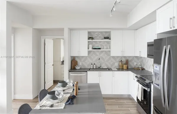 a kitchen with stainless steel appliances granite countertop a refrigerator and a stove top oven