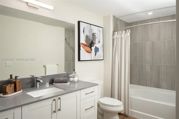 a bathroom with a granite countertop sink a toilet and a bathtub