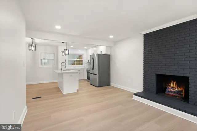 an empty room with windows and fireplace