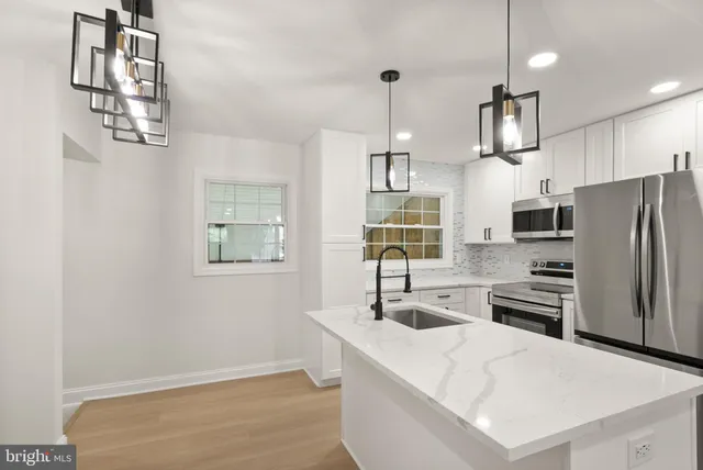a kitchen with a refrigerator sink and cabinets