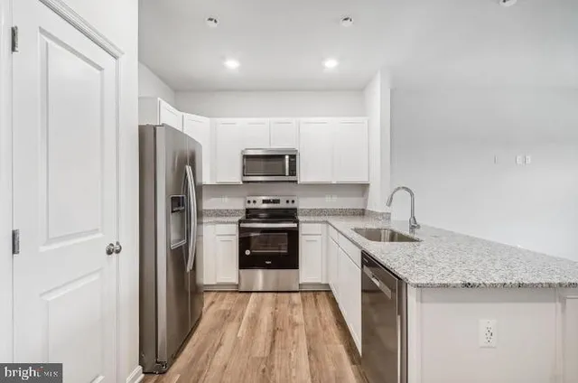 a kitchen with stainless steel appliances granite countertop a refrigerator and a sink