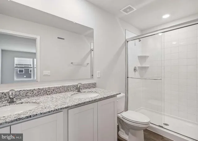 a bathroom with a granite countertop sink toilet and shower