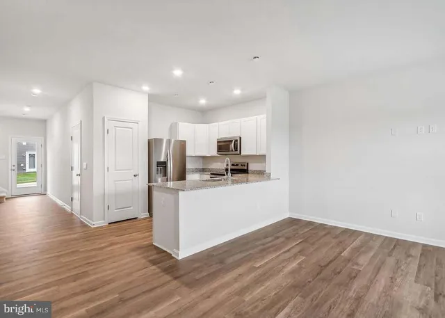 a view of kitchen with stainless steel appliances refrigerator stove microwave and cabinets