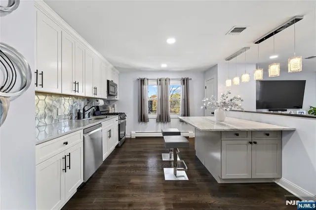 a kitchen with stainless steel appliances kitchen island granite countertop a sink and cabinets
