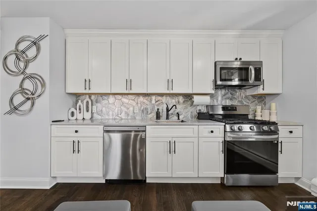 a kitchen with stainless steel appliances granite countertop a stove a sink and a microwave