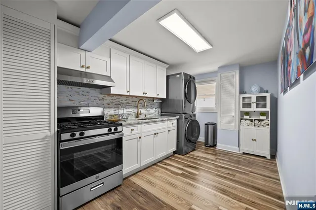 a kitchen with granite countertop a refrigerator stove and sink