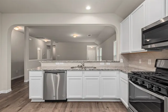 a kitchen with stainless steel appliances granite countertop a sink and a stove top oven