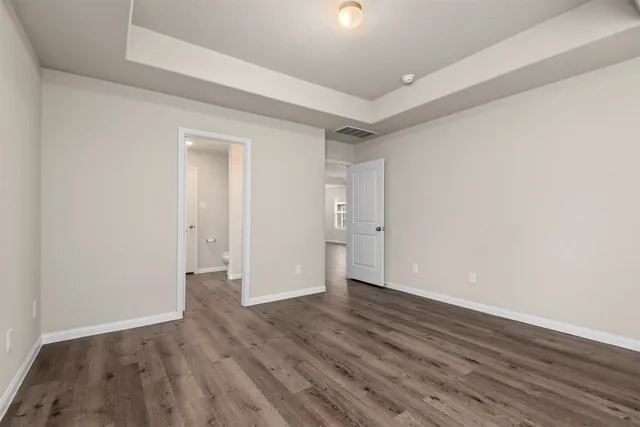 a view of an empty room with wooden floor