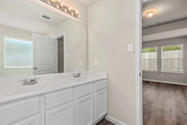 a spacious bathroom with a double vanity sink a mirror and a shower