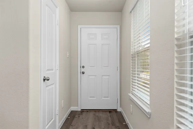 a view of a hallway with wooden floor and windows
