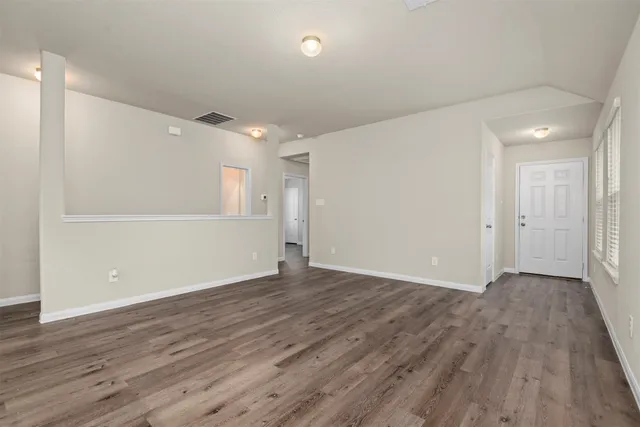 a view of an empty room with wooden floor