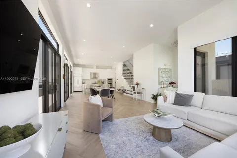 a living room with furniture and a view of kitchen