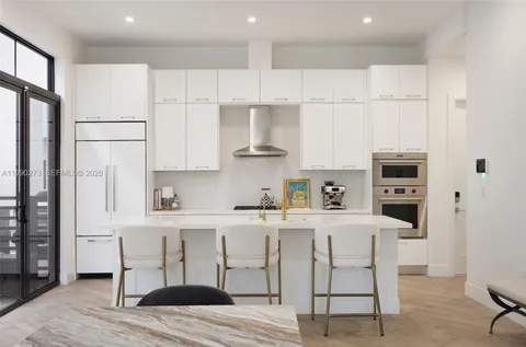 a kitchen with stainless steel appliances white cabinets and wooden floor
