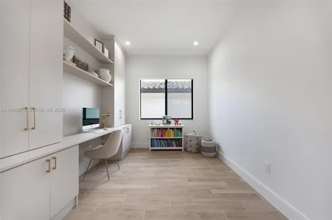 a room with a chair and white cabinets