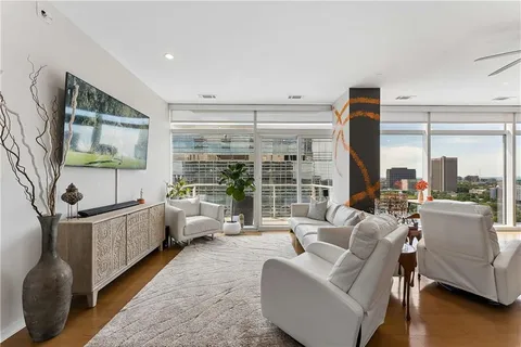 a living room with stainless steel appliances kitchen island granite countertop a table chairs and a view of living room