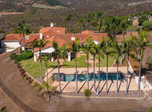 an aerial view of a house with swimming pool and patio