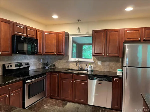 a kitchen with granite countertop sink and cabinets