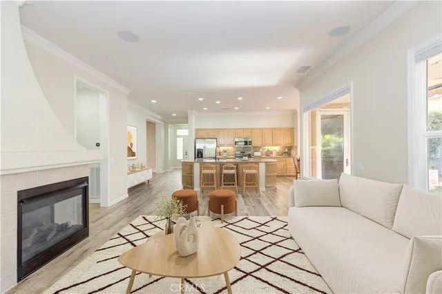 a living room with furniture a fireplace and a kitchen view