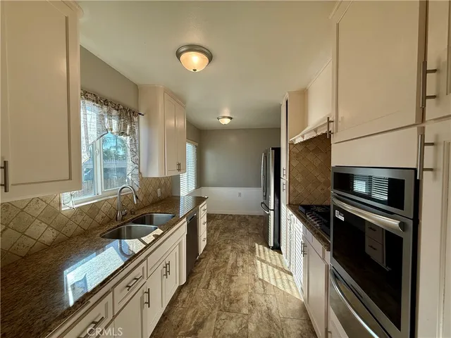 a kitchen with a sink and stainless steel appliances