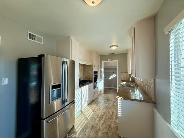 a kitchen with refrigerator and windows
