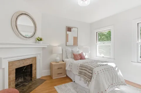 a bedroom with a bed a fireplace and a window