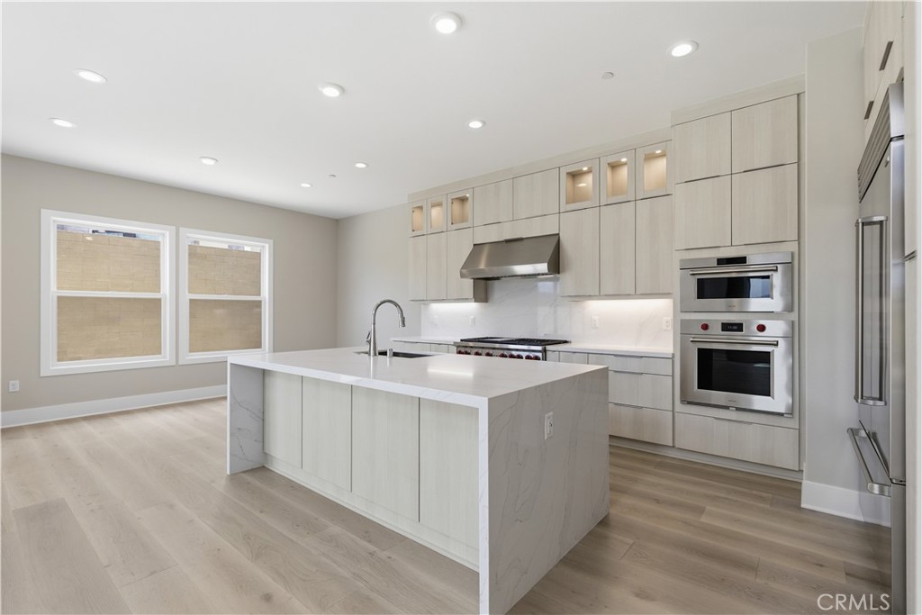 156 Apron Irvine, CA 92618 - Photo 5 of 40 a kitchen with stainless steel appliances granite countertop a stove a sink and a refrigerator
