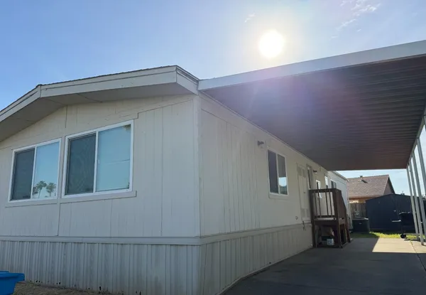 a kitchen with stainless steel appliances a stove a sink dishwasher a refrigerator and white cabinets with wooden floor