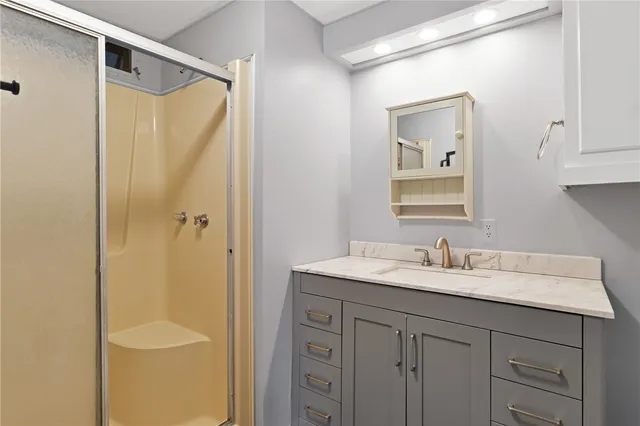 a bathroom with a granite countertop sink toilet and shower